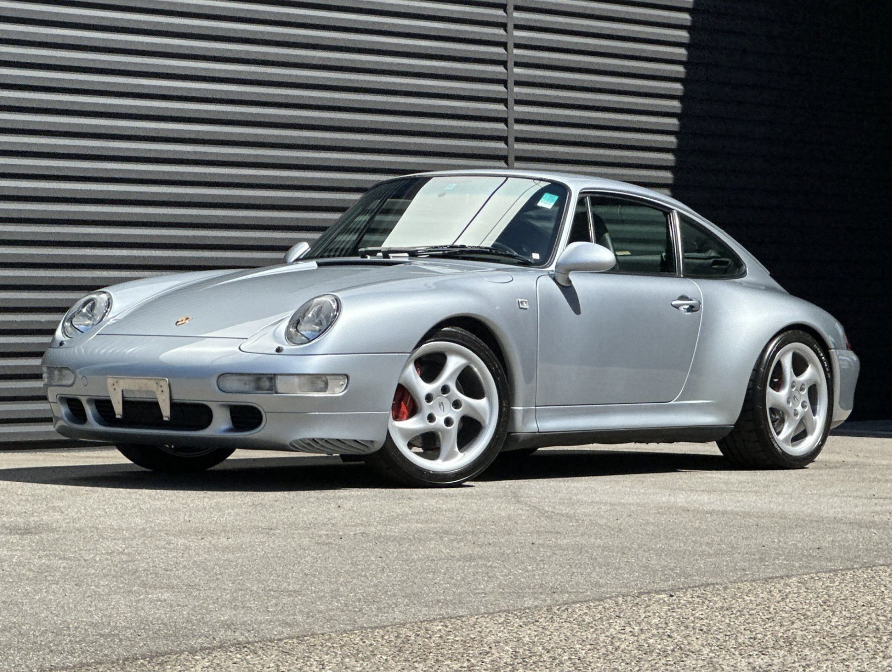 Silver Porsche 993 coupe from a front three-quarter angle